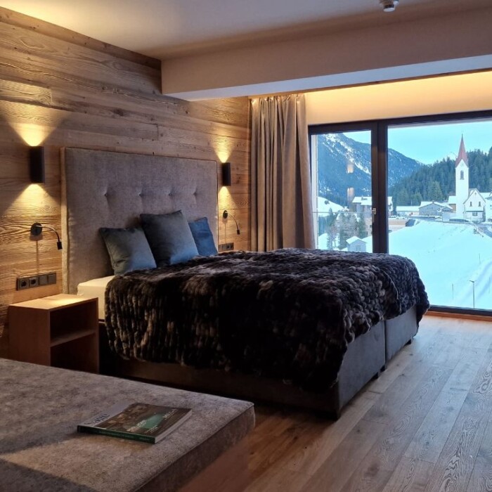 Lodge Arlberg - traumhafte Lage - großes Schlafzimmer mit Blick zur Kirche und in die Berge - Lech Valley Lodge in Warth am Arlberg - Österreich