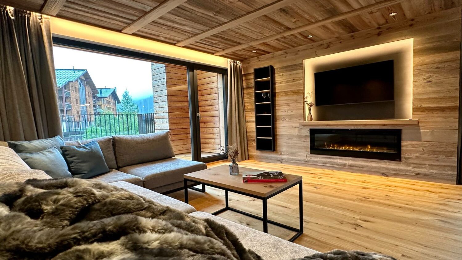 Luxus-Lodge am Arlberg mieten - NEU für 6 - 9 Personen - Wohnzimmer mit TV und Kamin, großer Balkon - Lech Valley Lodge