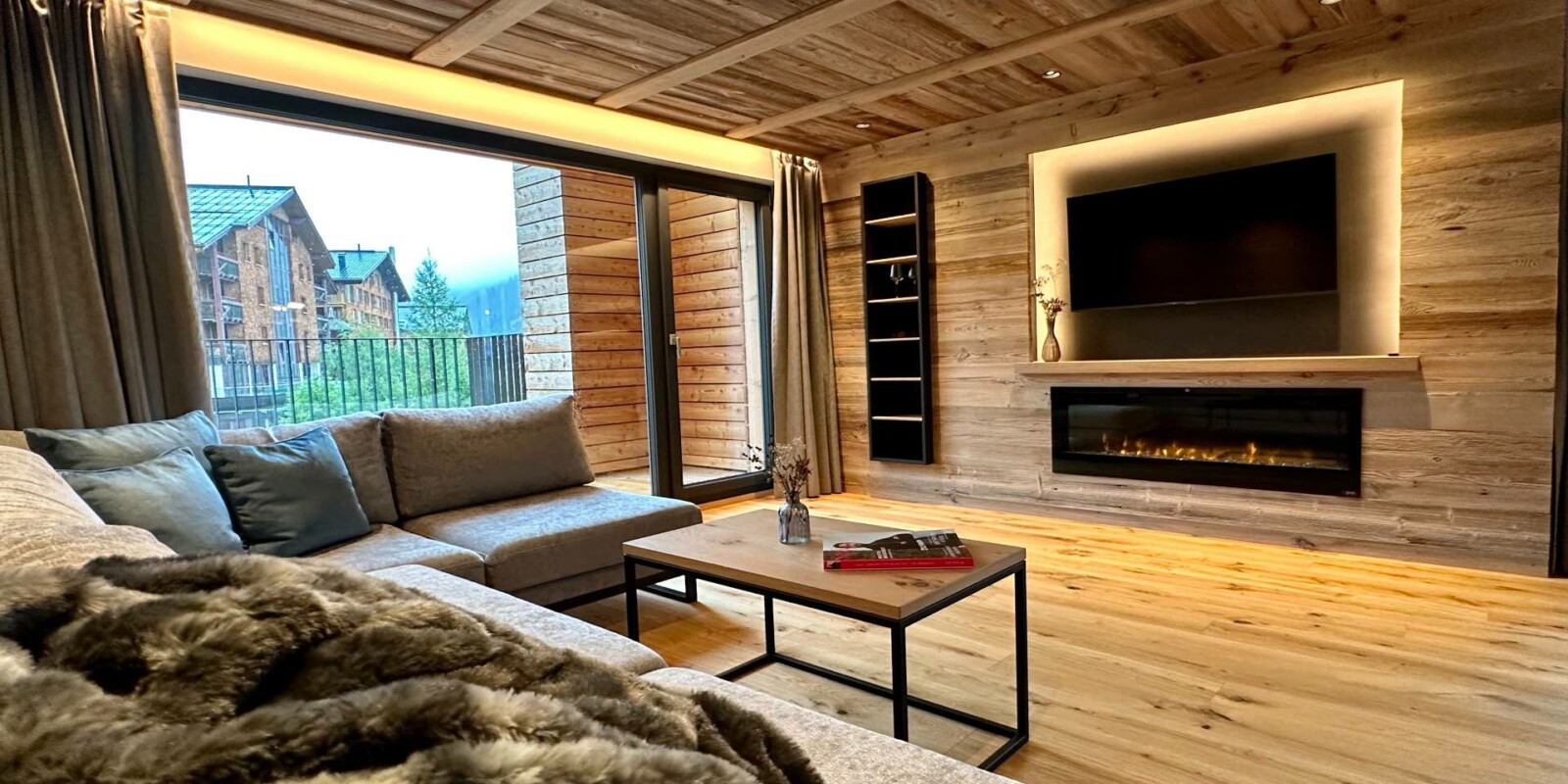 Luxus-Lodge am Arlberg mieten - NEU für 6 - 9 Personen - Wohnzimmer mit TV und Kamin, großer Balkon - Lech Valley Lodge