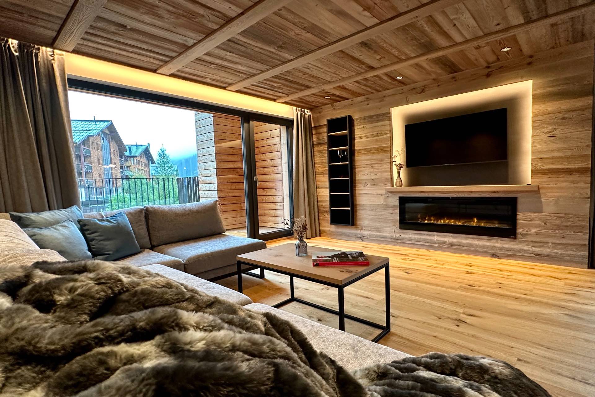 Luxus-Lodge am Arlberg mieten - NEU für 6 - 9 Personen - Wohnzimmer mit TV und Kamin, großer Balkon - Lech Valley Lodge