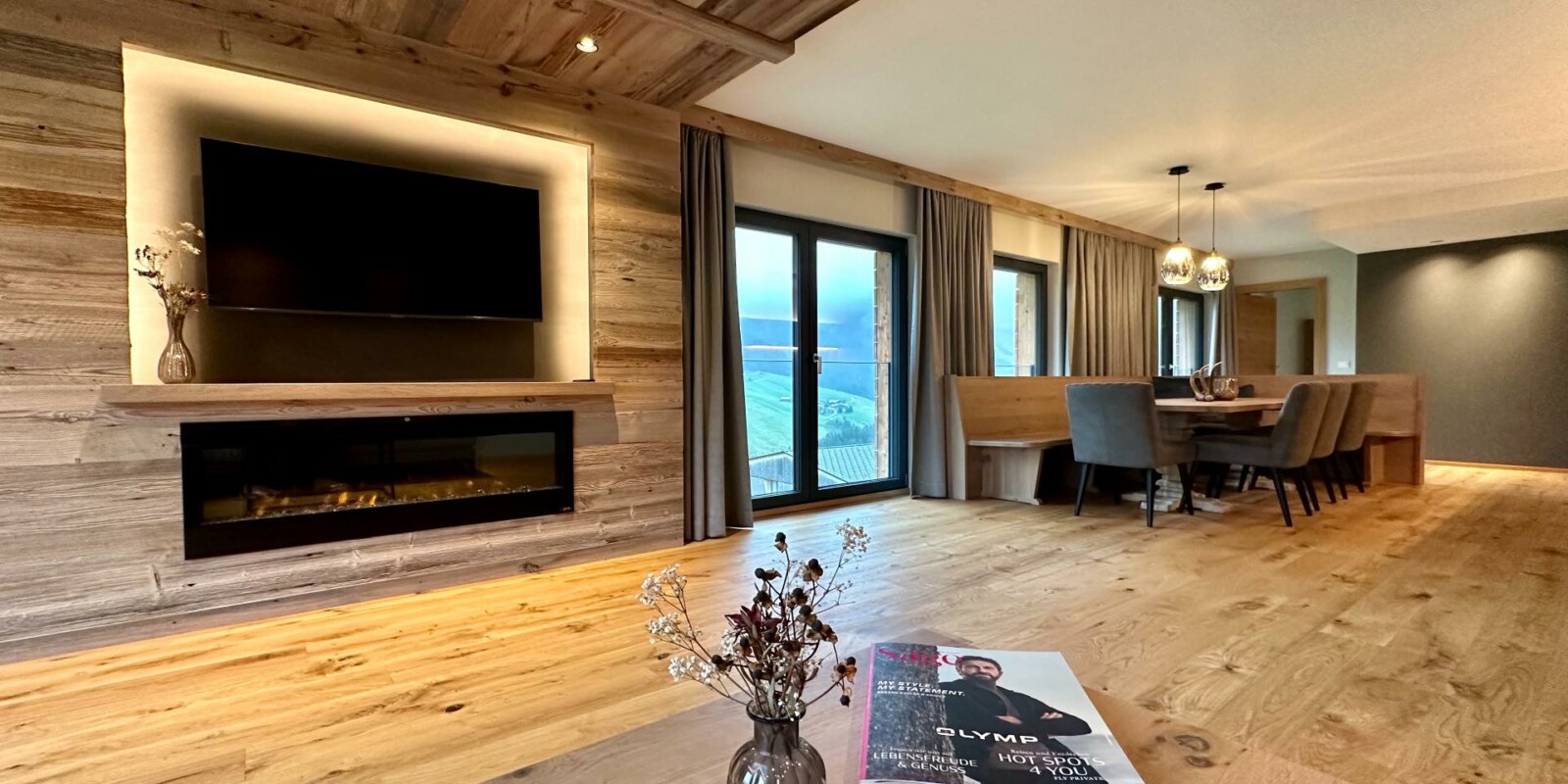 Luxus-Lodge am Arlberg in Österreich mieten - NEU für 6 - 9 Personen - Wohnzimmer mit TV und Kamin, Essbereich mit Küche und Balkon