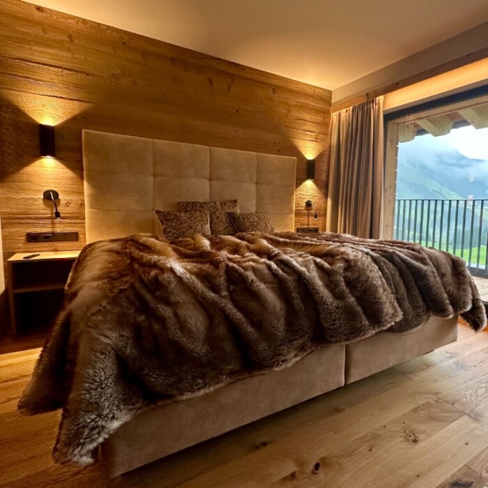Alpenchalet Schlafzimmer mit Balkon und traumhafter Blick in die Berge