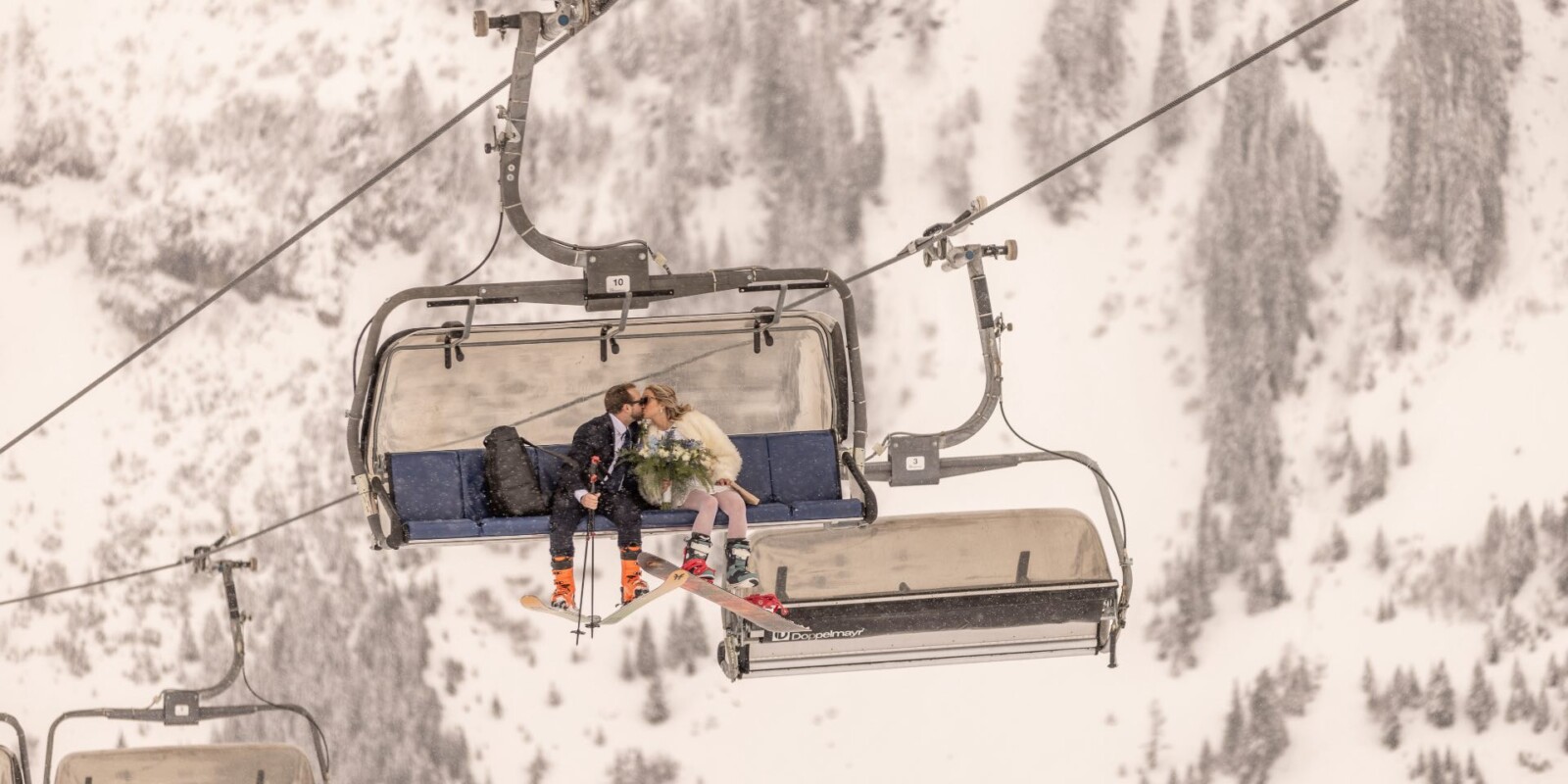 Hochzeit feiern in den Bergen am Arlberg – die schönste Hochzeitslocation für Brautpaare im Winter im Skigebiet – Brautpaar im Skilift in Österreich