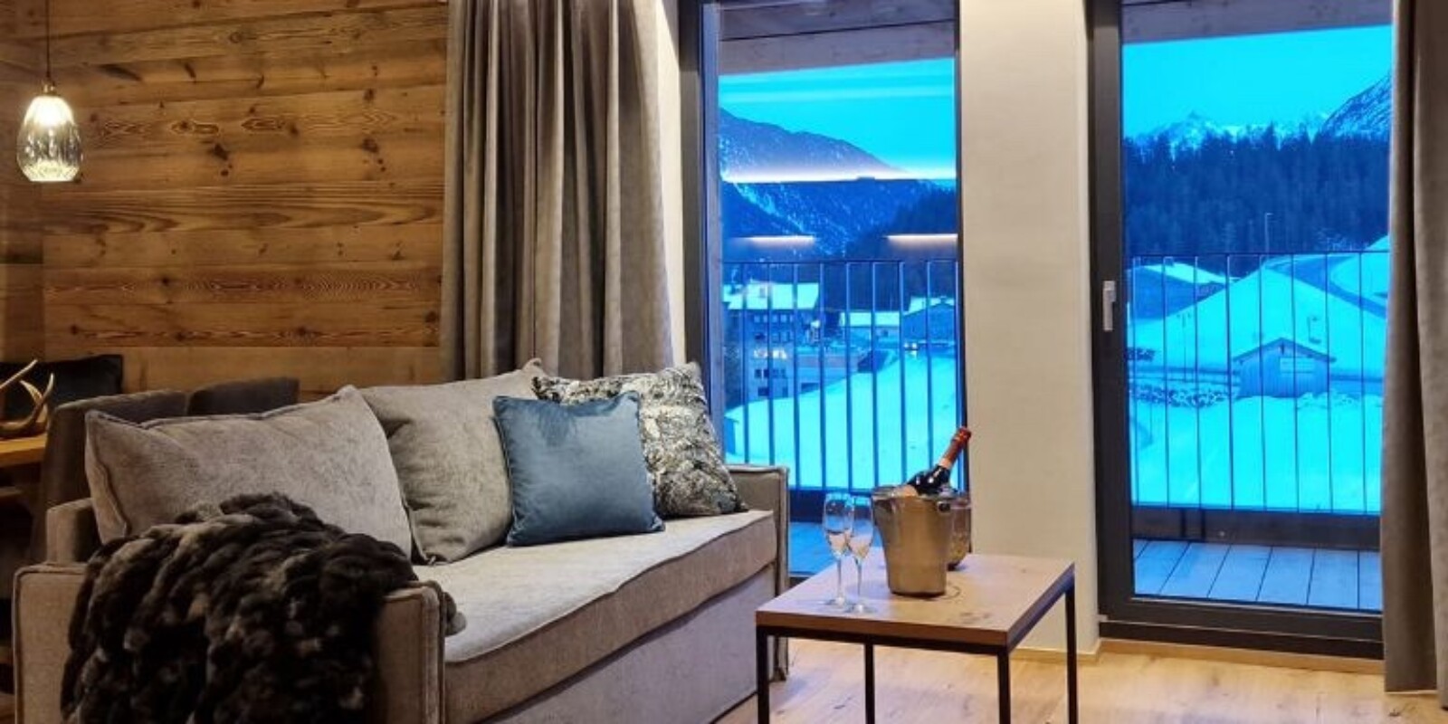 Lodge Arlberg in Österreich - Wohnbereich mit Kamin und Balkon im Winter - Aparthotel Lech Valley Lodge in Warth